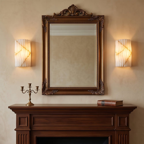 Deux appliques Isaure en albâtre strié allumées de chaque côté d’un miroir.