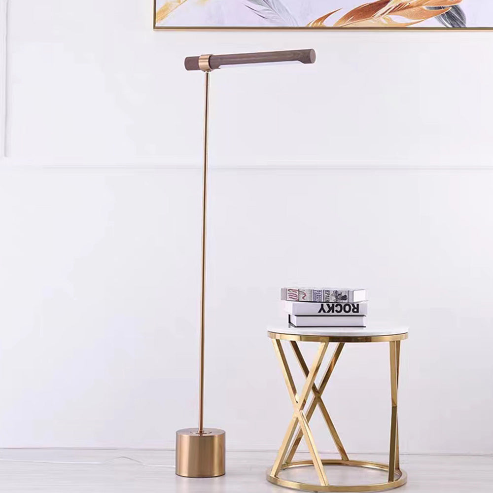 Lampadaire Simon doré placé près d’une table d’appoint ronde