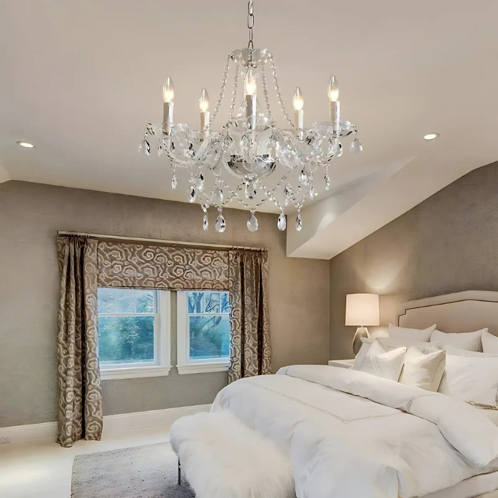 Lustre baroque Lorène allumé au plafond d’une chambre beige