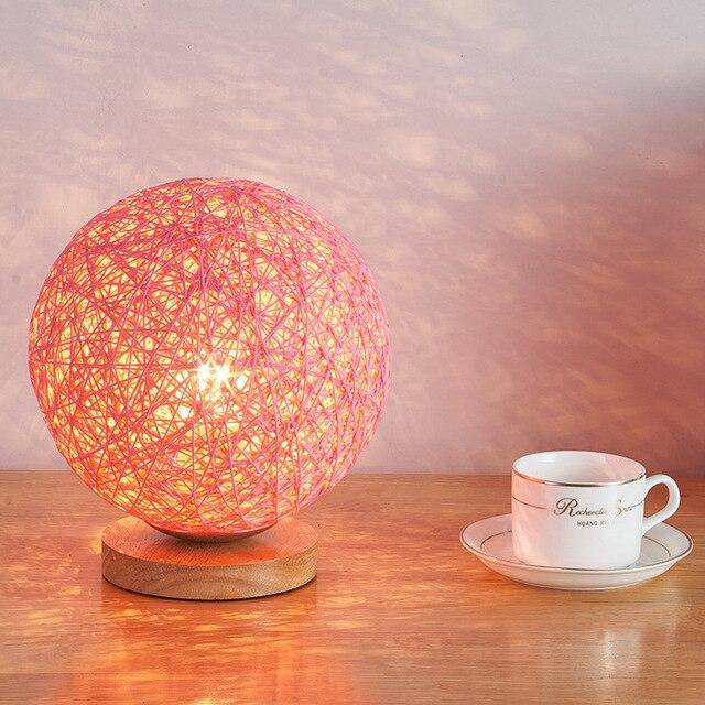 Lampe à poser LED avec socle bois et boule en tissu de couleur Wicker
